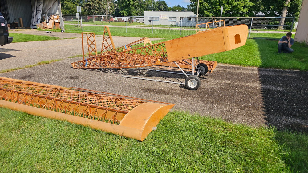 Side view of Fisher 303 fuselage on landing gear beside wing structure