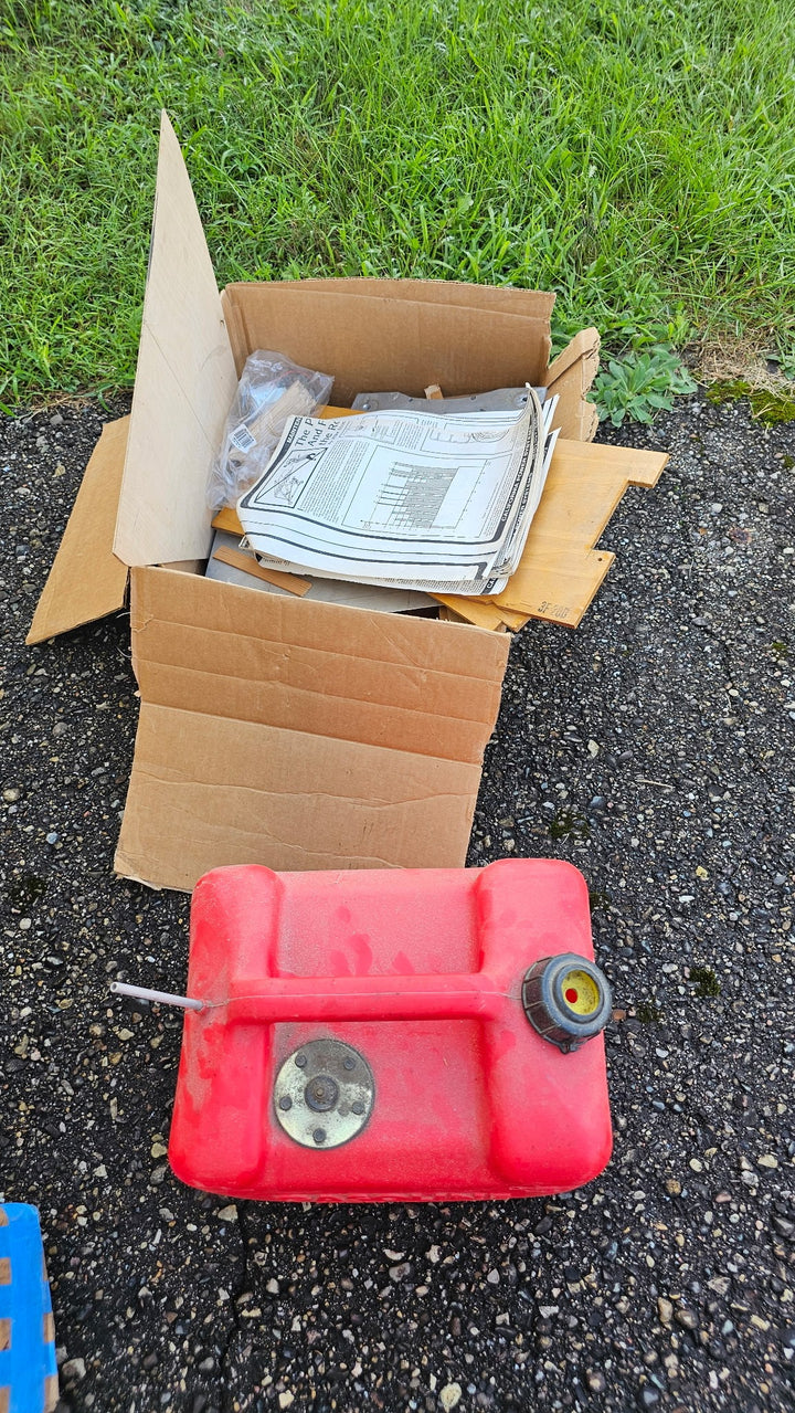 Loose Fisher 303 project parts and papers shown beside a red tank