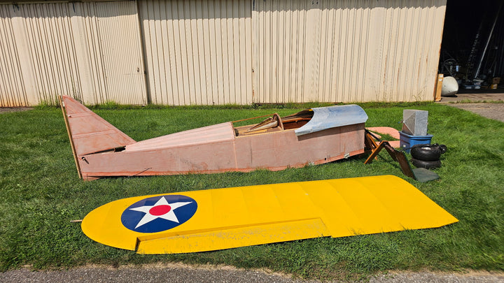 FlyBaby project fuselage with covered yellow wing and loose components